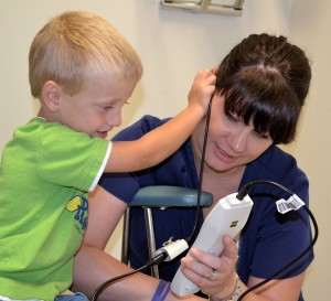 Wayne County Health Consultant Brenna Wolfe lets Levi Daniels perform a hearing test on her.