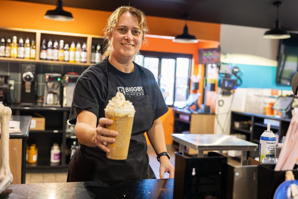 A woman holds a coffee.