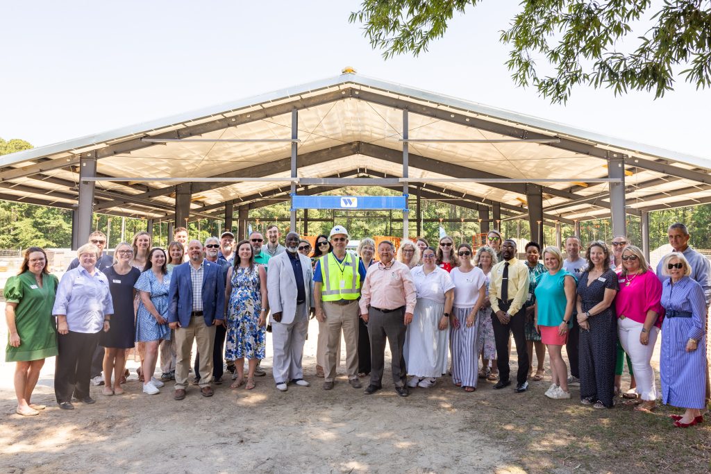 A group of individuals stand in front of a building under construction.