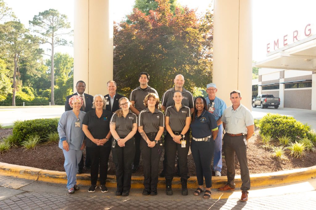 A group of individuals stand together outside of a hospital.