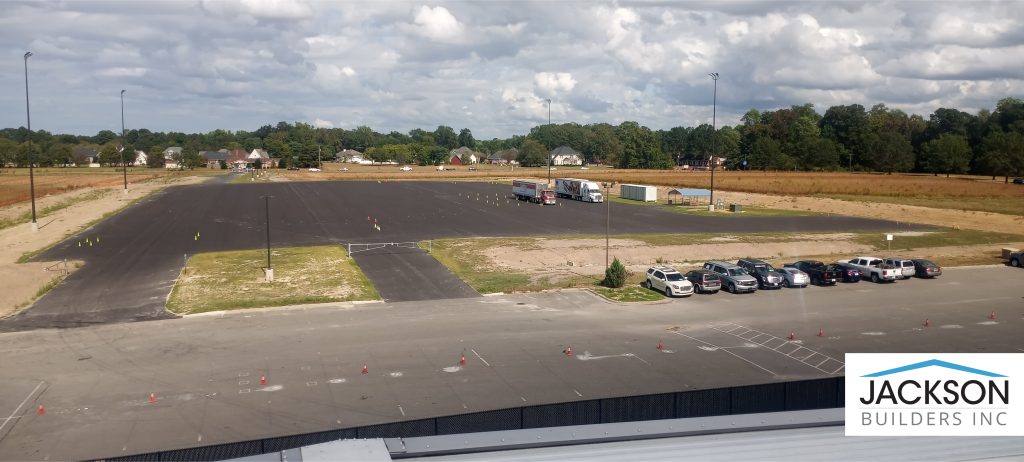 Two trucks sit on asphalt.