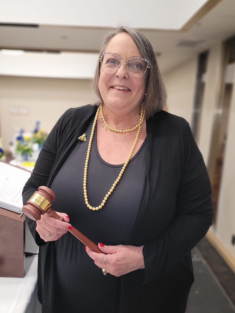 A woman holds a gavel.