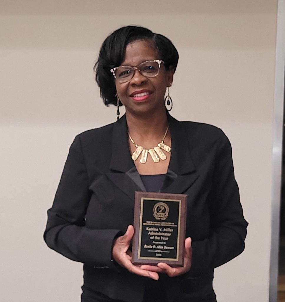 A woman holds a plaque.