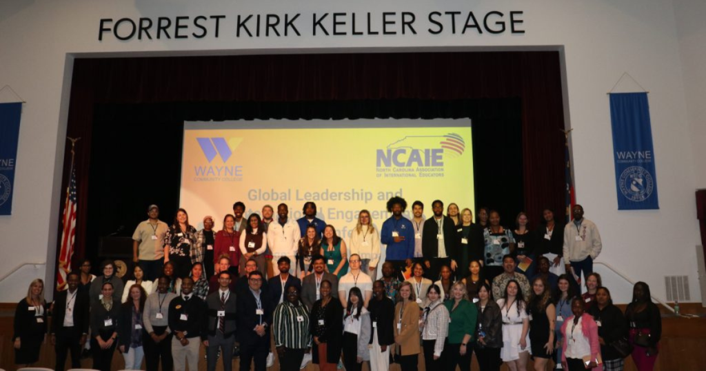 A group of individuals stand on a stage together.