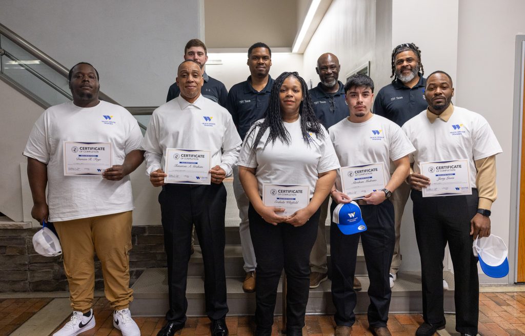 Individuals stand together holding certificates.