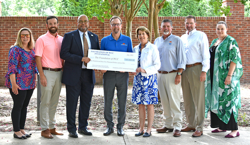 a group of men and women hold an oversized check