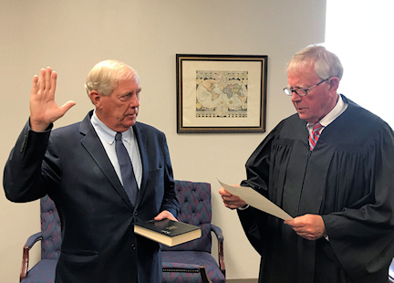 Judge administering oath to new trustee Geoff Hulse.