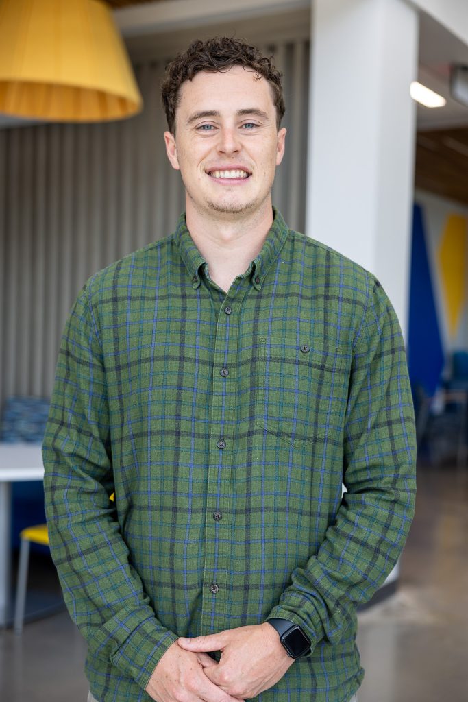 A man wearing a green shirt poses for a picture.