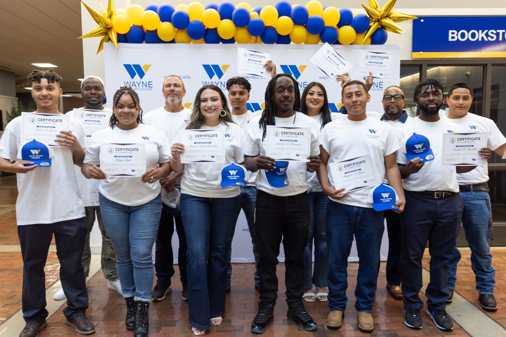 Individuals stand together holding certificates.